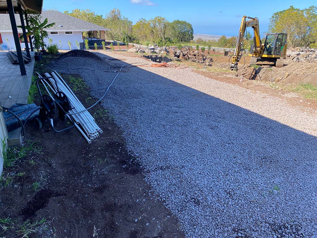 Hawaii Landscaper digging a trench near Kona as part of a landscape installation.