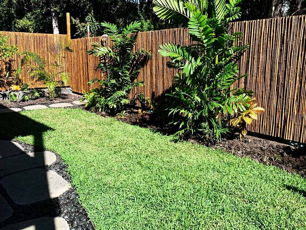 Kailua-Kona backyard landscape with river rocks, paving stones, and plants.