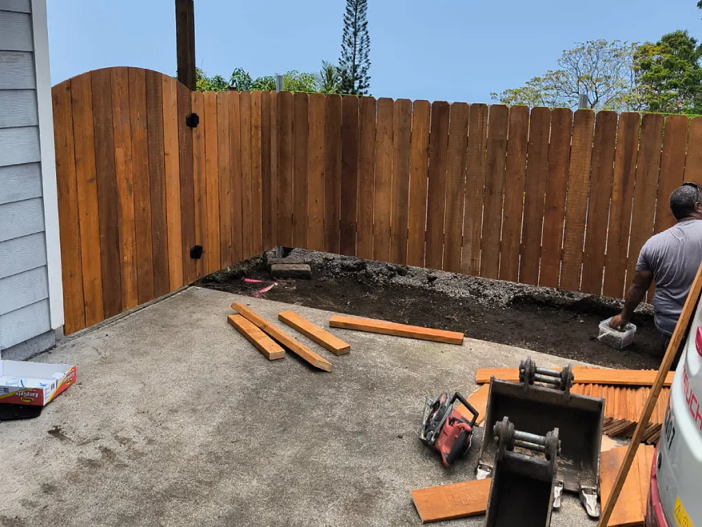 Professional Hawaii fence installer cuts lumber during fencing phase of the project.