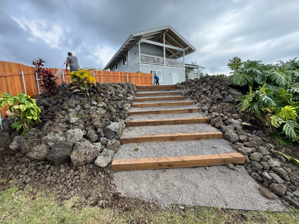Completed pathway staircase installation with moisture-resistant wooden beams, and crushed rock aggregate.