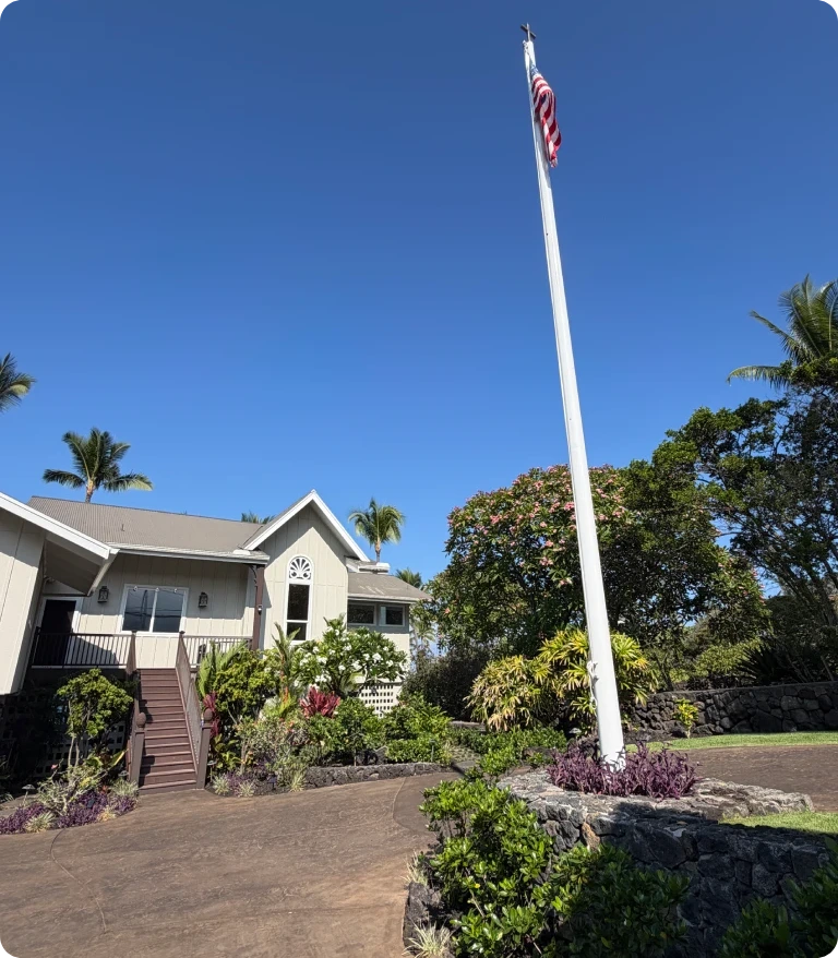 flag-kona-landscape-post Custom-built flagpole flying the American flag above a lava rock planter at a renovated Kona town estate.