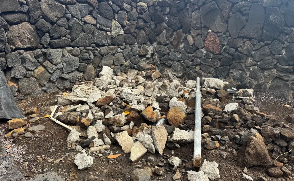 landscape-cleanup-before Concrete rubble inside a lava rock walled garden before clean-up and landscaping,
