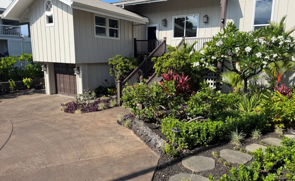 result-big-island-landscape Finished main house entry in Kailua-Kona with lava rock planter beds, tropical plantings, and stamped concrete driveway.