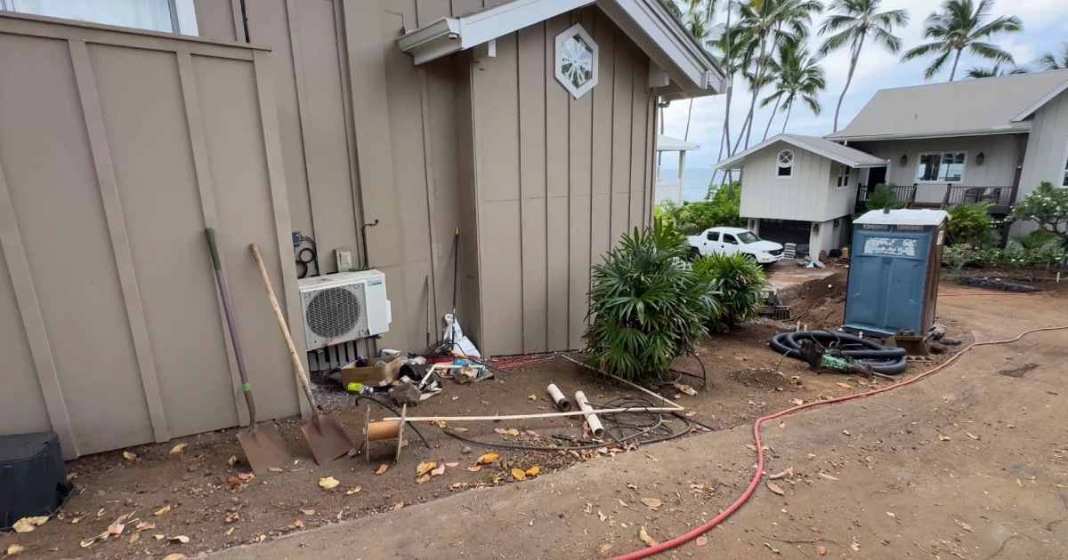 turf-and-flowerbed-before Bare dirt and tools beside the ohana house before turf and flowerbed installation at a beachfront Kailua-Kona estate.